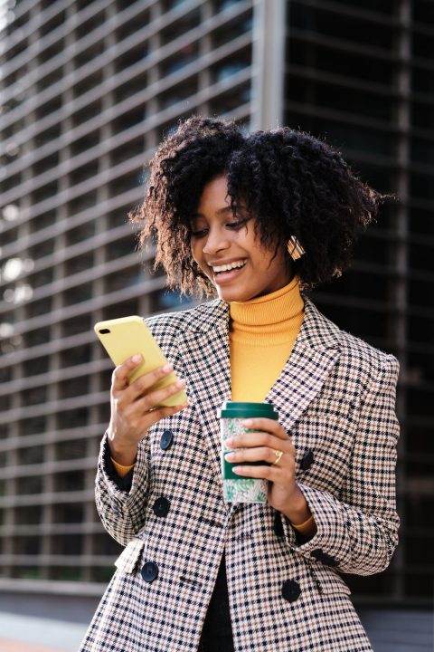 Afro business woman using her mobile phone.